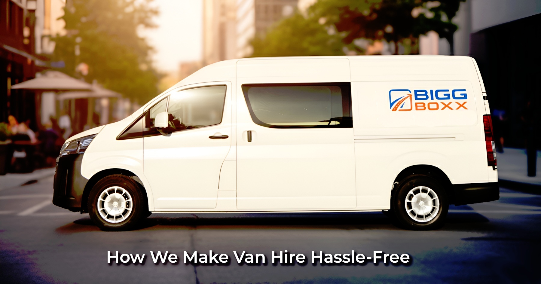 Side profile of a white Bigg Boxx rental van parked on a sunlit city street with a blurred urban background | How We Make Van Hire Hassle-Free | Bigg Boxx Rentals