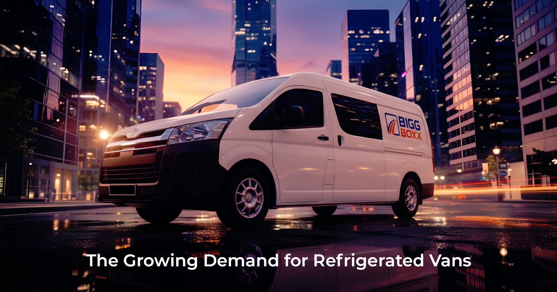 Side view of a white Bigg Boxx refrigerated rental van parked on a wet city street at night, with glowing skyscrapers and city lights in the background | The Growing Demand for Refrigerated Vans | Bigg Boxx Rentals